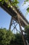 Under a train trellis against blue sky.