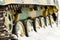 Undercarriage of a tank in the snow close-up of tracks and wheels