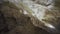 Underground cave formations of stalactites and stalagmites. Action. View inside of a cavern on giant stone walls.