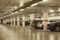 Underground parking lot with row of cars in a modern building. Blurred image