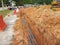 Underground utility and services pipe laid by workers in the trenches at the construction site.