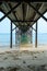 Underneath the pylons of a long jetty pier