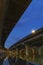 Underside of an elevated road across river at dusk