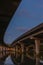 Underside of an elevated road across river at dusk