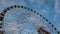 Underside view of a ferris wheel over blue sky