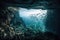 underwater cave with view of the open ocean, with schools of fish swimming by