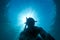 Underwater diver under the rays of light of the sun in a deep blue sea