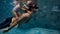 Underwater. father and his daughter swim in the pool on dad`s day.