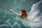 Underwater girl. Beautiful red-haired woman in a white dress, swimming under water.