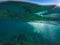 Underwater landscape with natural water split, blue sky above and green water below.