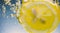 Underwater lemon slice in soda water or lemonade with bubbles