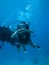 Underwater shoot of a young woman diving and showing love signal