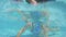 Underwater shot of little girl diving in a swimming pool