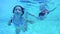 Underwater shot of two kids diving in a swimming pool