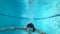 Underwater swimming, girl plunges into pool and float with open eyes in pure water