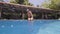 Underwater view man emerges from outdoor swimming pool in resort hotel. Swimmer man in swimming mask emerge from