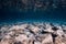 Underwater view with stones bottom, reflection in water. Ocean background