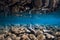 Underwater view with stones, reflection and blue water