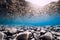 Underwater view with stones, reflection and blue water