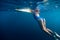 Underwater woman in blue bikini with surfboard relaxing in ocean