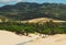 Undulating sand dunes against the backdrop of a majestic mountain in the horizon