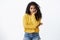 Uneasy and sad cute african american curly-haired girl in yellow sweater feeling lonely and bored, lean head on palm