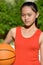 Unemotional Asian Female Athlete With Basketball
