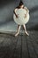 Unemotional ballet dancer hugging the white balloon in the studio