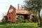 Unfinished abandoned brick house surrounded with high vegetation