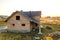 Unfinished brick house with wooden roof structure covered with metal tile sheets under construction