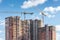 unfinished high-rise building and tower cranes on blue sky background