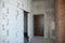Unfinished house entrance room with metal entrance door