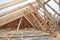 Unfinished house rooftop roofing construction attic trusses, wooden beams, eaves, timber.  House roof wooden frame construction