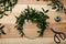 Unfinished mistletoe wreath and florist supplies on wooden table, flat lay. Traditional Christmas decor