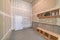 Unfinished mudroom interior with seat and shelving units