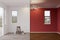 Unfinished Raw and Newly Remodeled Room of House Before and After with Wood Floors, Moulding, Dark Red Paint and Ceiling Lights