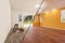 Unfinished Raw and Newly Remodeled Room of House Before and After with Wood Floors, Moulding, Yellow Ochre Paint and Ceiling