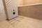 Unfinished reconstruction of bathroom with ceramic tiles installed on walls, heating electrical cables system on cement floor and