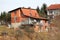 Unfinished red building block suburban family house with large open balcony in front and unusually shaped roof