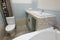 Unfinished repairs in bathroom, a pedestal under the washbasin, under which there is a washing machine, and a toilet bowl