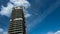 Unfinished residential building under blue sky and clouds, construction crane work, copy space