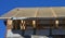 Unfinished roofing construction with a close-up on ceiling joists, wooden rafters, strutting beams, and roof sheathing on a vapor