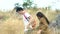 Unfocus young Asian couple holding hands enjoying together in golden meadow trail, Partner talking during trekking romantic vacati