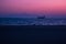 Unfocused beautiful pink and blue sunset colors twilight empty evening waterfront concrete city road along ocean shoreline with