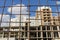 Unfocused building construction process silhouette behind rusty industrial fence grid foreground