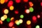 Unfocused colorful christmas lights on dark background with bokeh effect