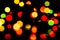 Unfocused glowing geometric shape shiny colorful christmas lights with reflections on black