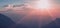 Unfocused idyllic sun set rays of light above mountain silhouettes picturesque landscape wallpaper background pattern space for
