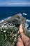 unfocused legs and feet of a caucasian boy on the big rocks of the cliffs next to the strong waves of the cantabrian sea