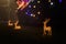 Unfocused night shot of Christmas reindeers and garland lights bokeh in the city. Happy New Year, Merry Christmas